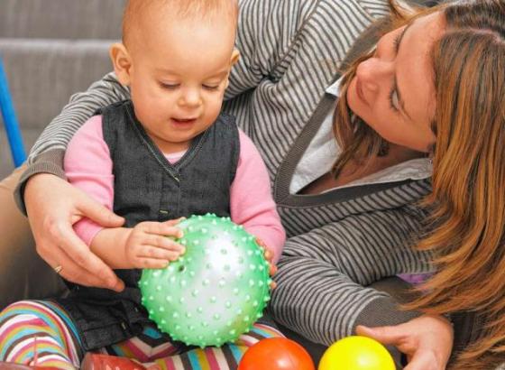 mom playing with infant with ball